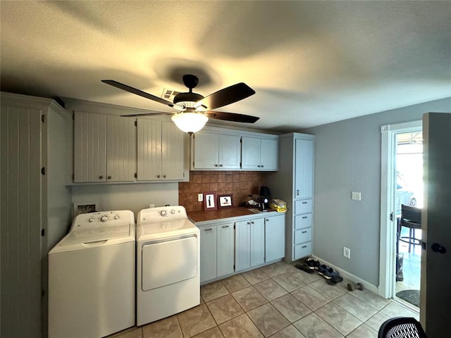 laundry room with cabinets, ceiling fan, washing machine and dryer, a textured ceiling, and light tile patterned flooring