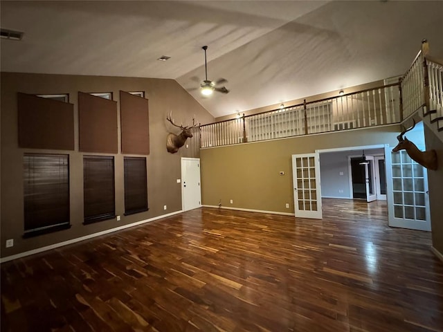 unfurnished living room with french doors, high vaulted ceiling, ceiling fan, and dark wood-type flooring