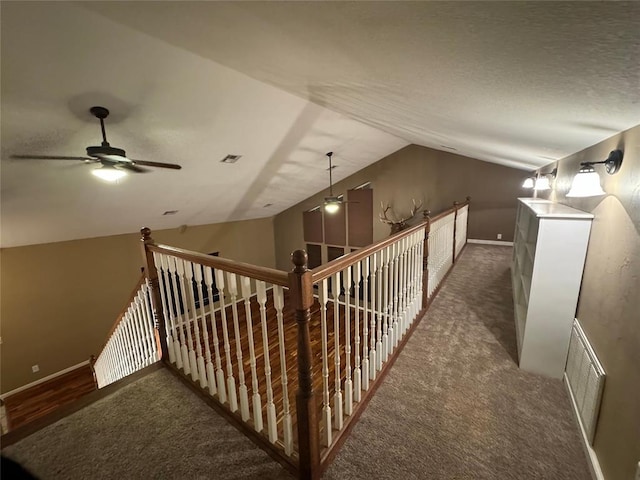 interior space featuring dark carpet, ceiling fan, and lofted ceiling