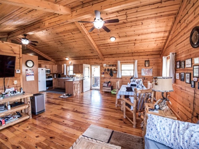 living room featuring light wood-type flooring, lofted ceiling with beams, wooden walls, and wood ceiling