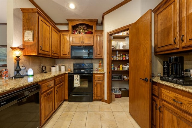 kitchen with decorative backsplash, light stone countertops, ornamental molding, black appliances, and light tile patterned floors