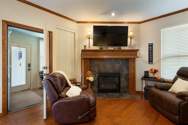 sitting room with hardwood / wood-style floors, ornamental molding, a fireplace, and a wealth of natural light