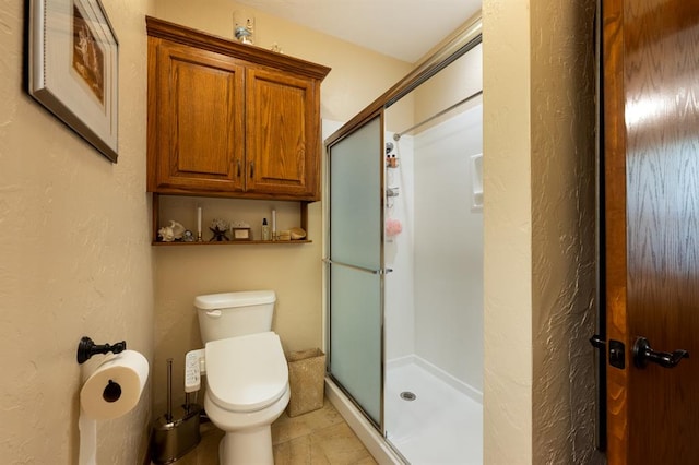 bathroom featuring walk in shower, tile patterned flooring, and toilet