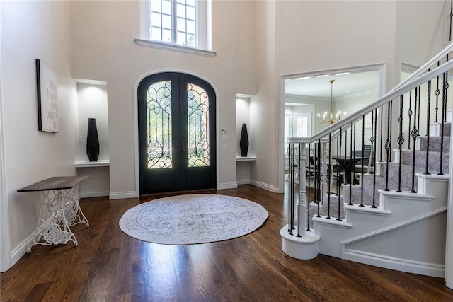 foyer entrance with plenty of natural light, dark hardwood / wood-style flooring, a high ceiling, and french doors