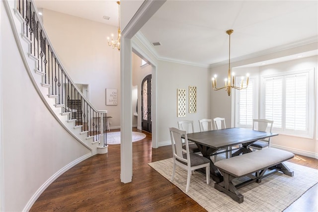 dining space with crown molding, dark wood-type flooring, and a chandelier