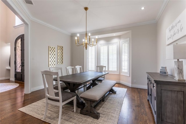 dining room with dark hardwood / wood-style flooring, an inviting chandelier, and ornamental molding