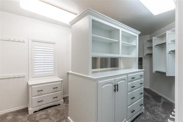 walk in closet featuring dark colored carpet