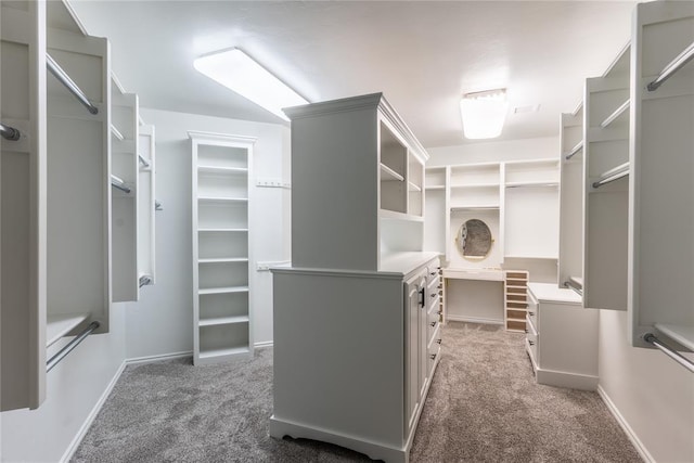 walk in closet featuring light colored carpet