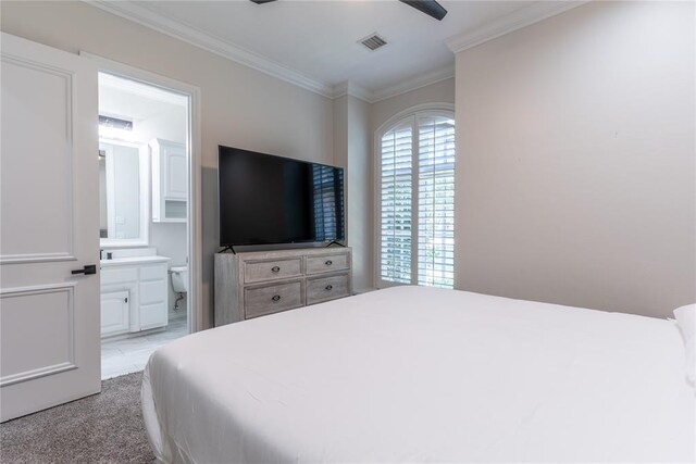 carpeted bedroom with ensuite bath, ceiling fan, and ornamental molding