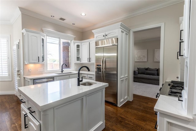 kitchen with stainless steel appliances, dark wood-type flooring, sink, a center island with sink, and white cabinets