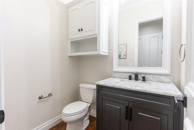 bathroom with vanity, hardwood / wood-style flooring, toilet, and ornamental molding