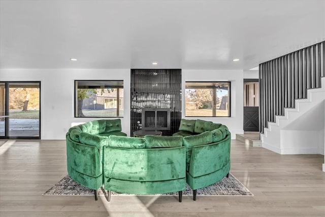 living room featuring a fireplace, a wealth of natural light, and hardwood / wood-style floors