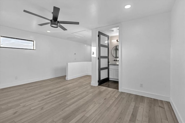 empty room with ceiling fan and light hardwood / wood-style flooring