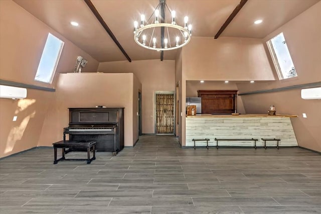 living room with a wall mounted AC, vaulted ceiling with skylight, wood-type flooring, and an inviting chandelier