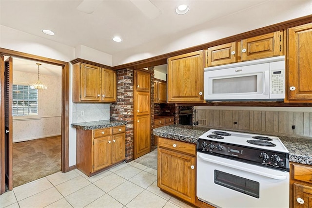 kitchen featuring white appliances, an inviting chandelier, light tile patterned floors, tasteful backsplash, and decorative light fixtures