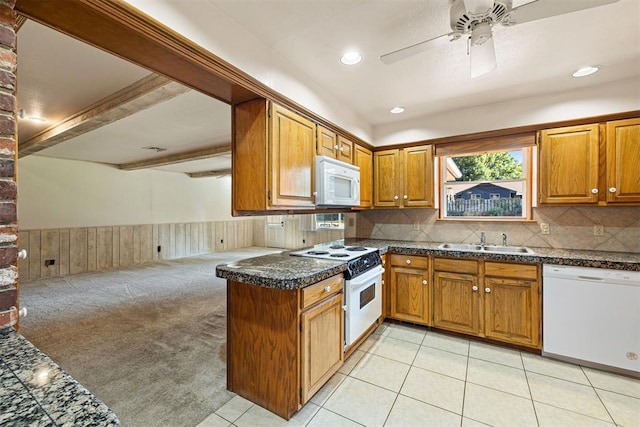 kitchen with white appliances, sink, ceiling fan, light colored carpet, and kitchen peninsula