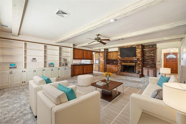 living room with beamed ceiling, ceiling fan, built in shelves, and a brick fireplace