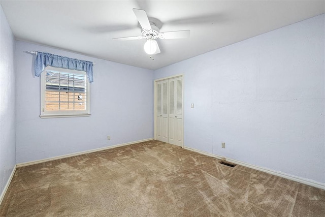 spare room with ceiling fan and carpet