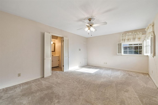 unfurnished bedroom with ceiling fan, light colored carpet, and ensuite bathroom