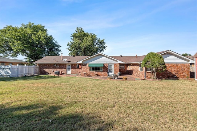 rear view of house featuring a lawn and a patio area