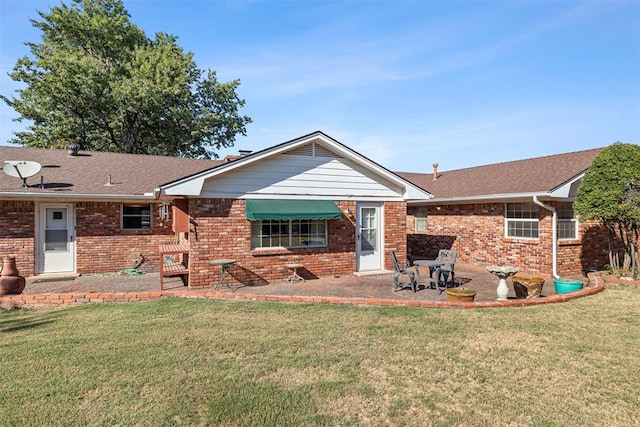 rear view of property featuring a lawn and a patio area