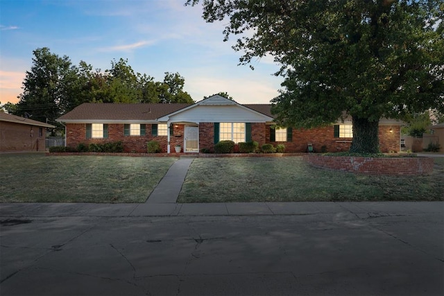 ranch-style home with a yard