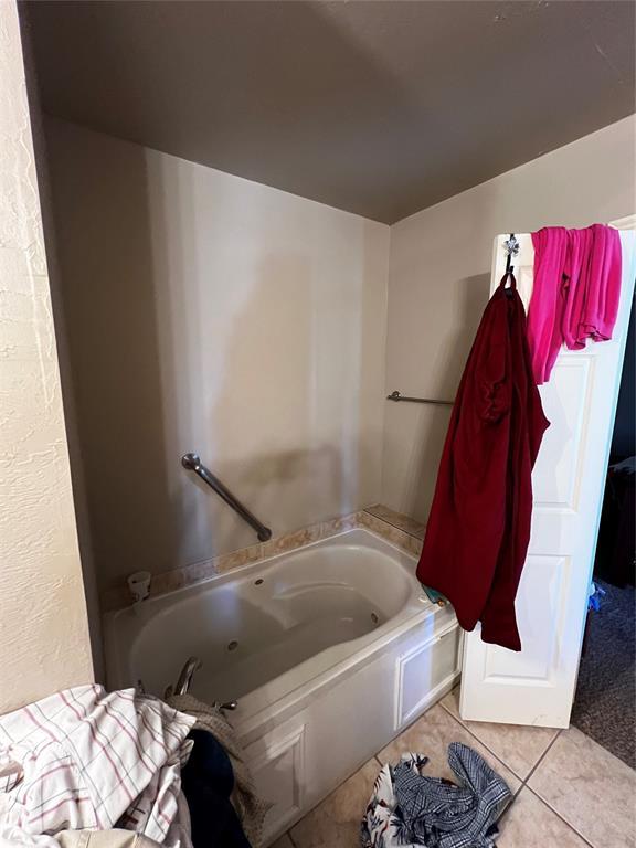 bathroom with tile patterned flooring and a bathing tub