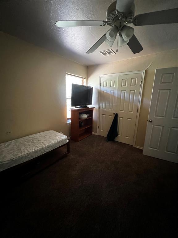 bedroom featuring a textured ceiling, carpet floors, and ceiling fan