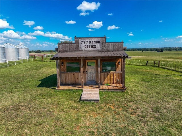 view of outbuilding featuring a rural view and a yard