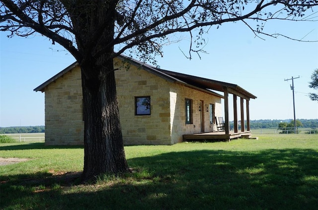 view of side of property with a lawn and a deck