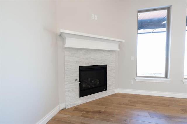 interior details with hardwood / wood-style floors and a stone fireplace