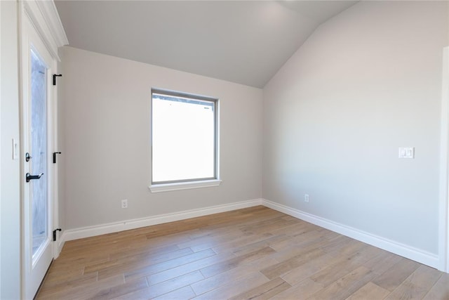 unfurnished room with lofted ceiling and light wood-type flooring