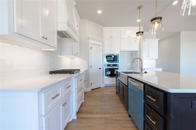 kitchen featuring white cabinetry, appliances with stainless steel finishes, and a kitchen island with sink