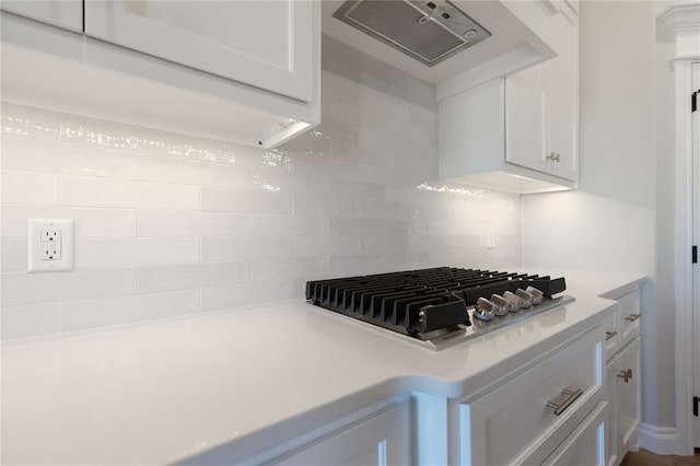 kitchen with white cabinets, backsplash, wall chimney exhaust hood, and stainless steel gas stovetop