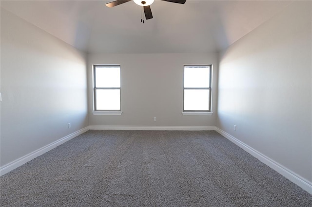 spare room featuring vaulted ceiling, carpet flooring, and ceiling fan