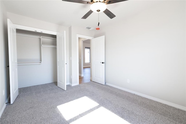 unfurnished bedroom featuring light colored carpet, a closet, and ceiling fan