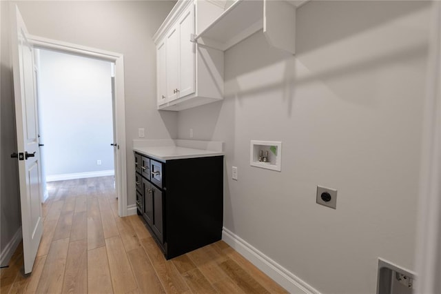 laundry room featuring hookup for an electric dryer, cabinets, washer hookup, and light hardwood / wood-style flooring