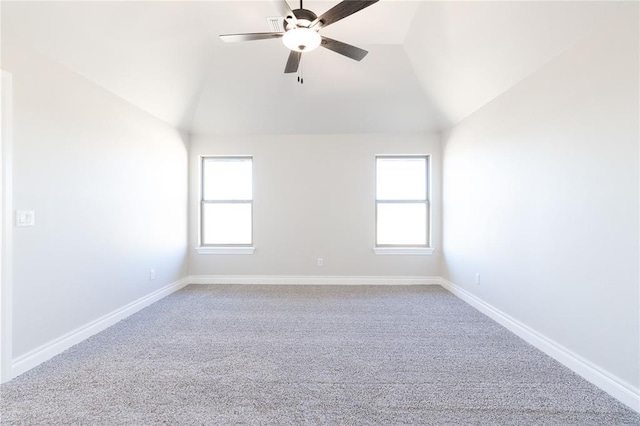 carpeted spare room with a wealth of natural light, baseboards, vaulted ceiling, and a ceiling fan