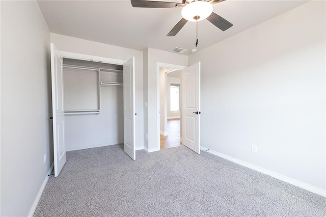 unfurnished bedroom with ceiling fan, a closet, visible vents, carpet floors, and baseboards