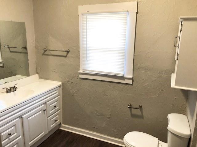 bathroom with vanity, toilet, and wood-type flooring