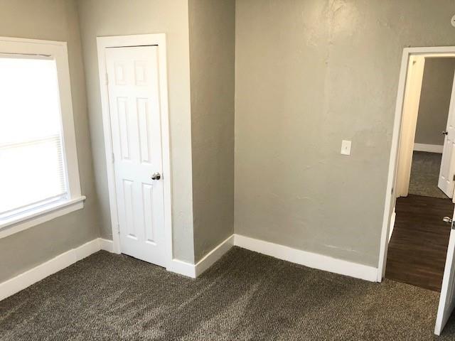 unfurnished bedroom featuring dark carpet