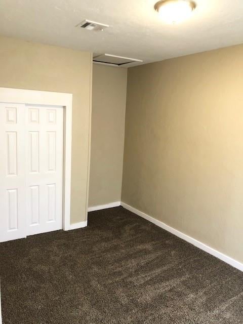 spare room with dark colored carpet