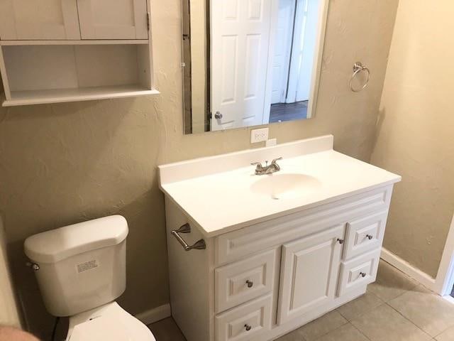 bathroom featuring tile patterned flooring, vanity, and toilet