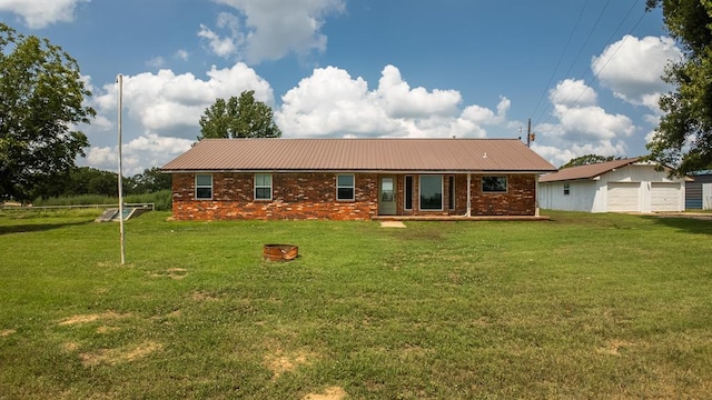 rear view of house featuring an outdoor structure and a lawn