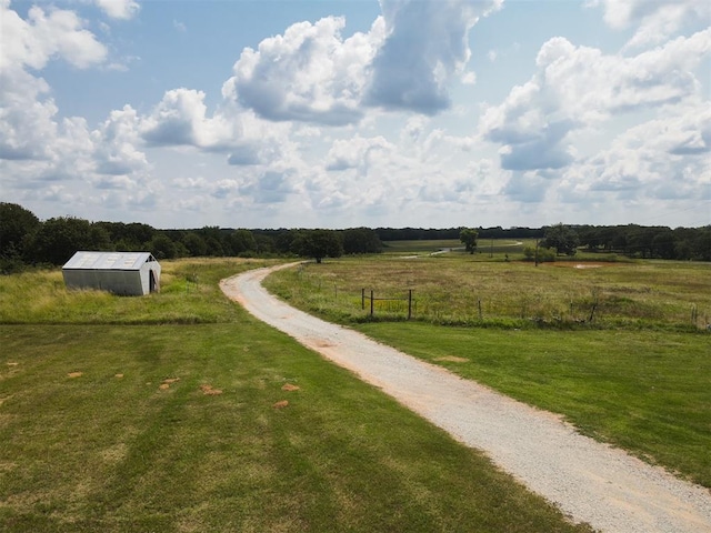 view of property's community featuring a lawn and a rural view