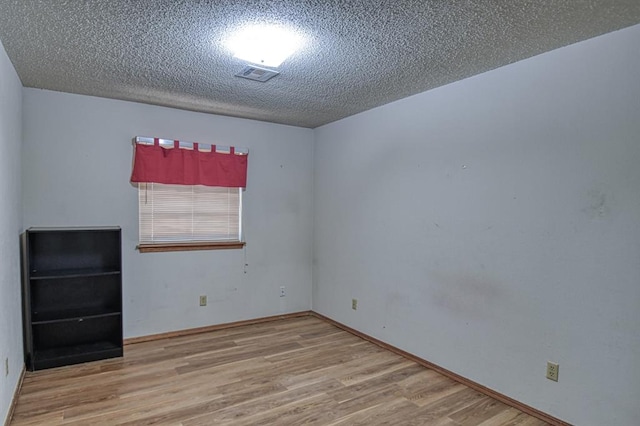 empty room featuring hardwood / wood-style floors and a textured ceiling