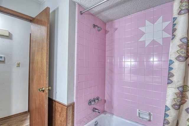 bathroom featuring hardwood / wood-style floors, a textured ceiling, and shower / bath combo