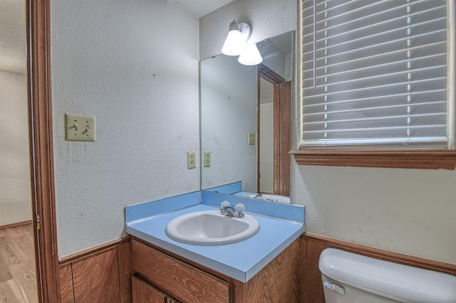 bathroom featuring wood-type flooring, vanity, and toilet