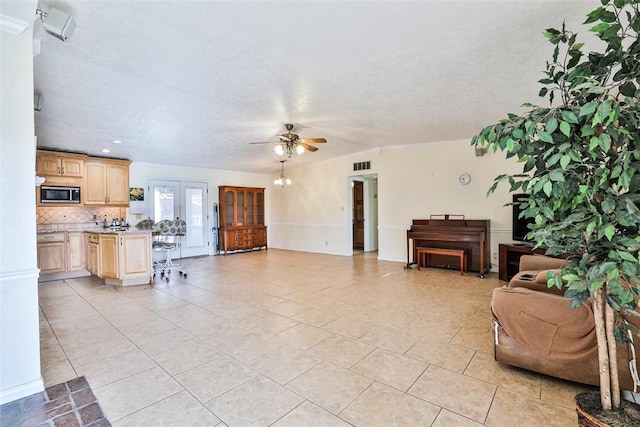 tiled living room with ceiling fan, french doors, and a textured ceiling