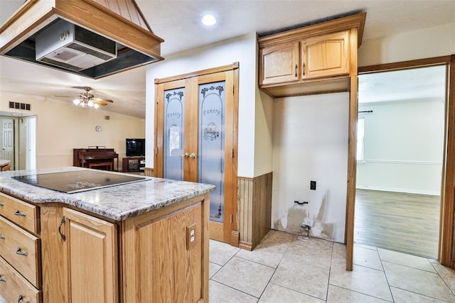 kitchen featuring black electric stovetop, custom exhaust hood, ceiling fan, and light tile patterned floors